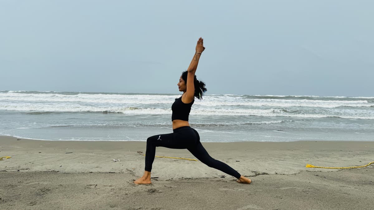 Warrior I pose on the beach